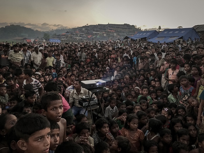 2018 iPhone Fotoğraf Ödülleri açıklandı, Türkiye’den 3 isim yer aldı Rohingya children watching an awarness film about health and sanitation near Tangkhali refugee camp in Ukhiya. More than 655,000 Rohingya who have fled to Bangladesh since the Myanmar military began its crackdown in late August.Almost 60 per cent of the refugees are children. Many have become separated from their families or fled on their own. Women and children fleeing from Myanmar’s Rakhine State into Bangladesh have reported experiencing or witnessing brutal acts of violence – accounts which point to grave human rights violations.  Around 380,000 are minors, according to Save the Children, the international aid organization. At least 30 percent of the refugee population is younger than 5 And the threat to young lives doesn’t end when they cross the border. Unicef says that 7 percent of children in the camps are suffering from severe acute malnutrition, a condition from which they will die unless they get proper care. That figure is three times higher than in other recent humanitarian emergencies. Outbreaks of communicable diseases, such as measles and diphthera are sweeping through the overcrowded camps, which, with the recent influx, now house more than 800,000 Rohingya. Other dangers lurk in the disorderly setting of the camps, including traffickers and others looking to exploit and abuse the young and vulnerable. hundreds of thousands of Rohingya children will grow up both stateless and homeless an untethered life of displacement that bodes ill for a people already wounded by decades of military persecution in Rakhine State.